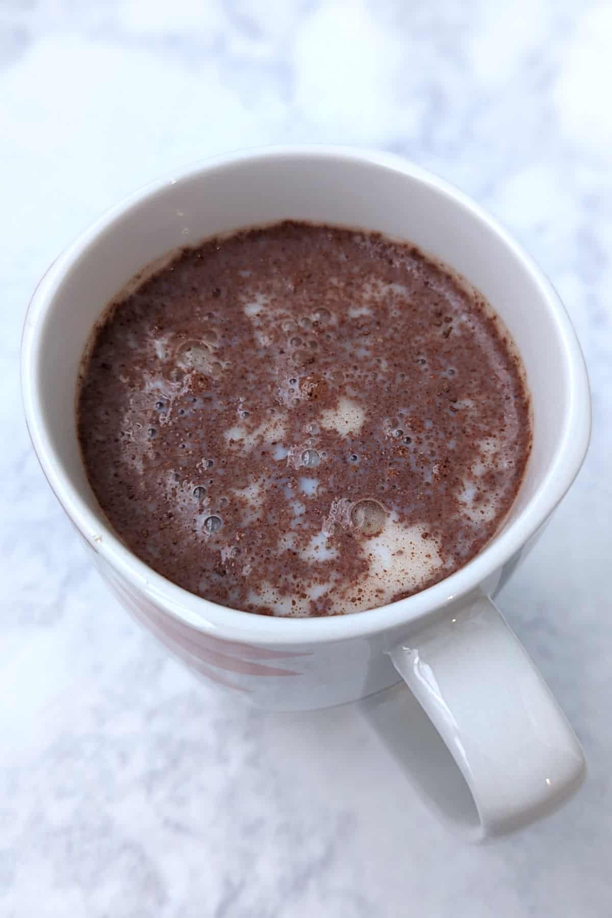 sweet hot chocolate mix with milk in a mug, before mixing