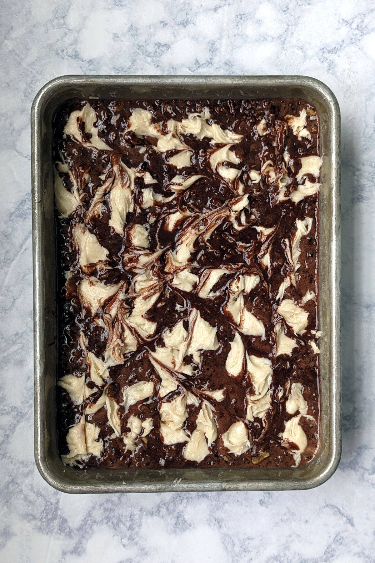 cream cheese frosting swirled into chocolate cake batter