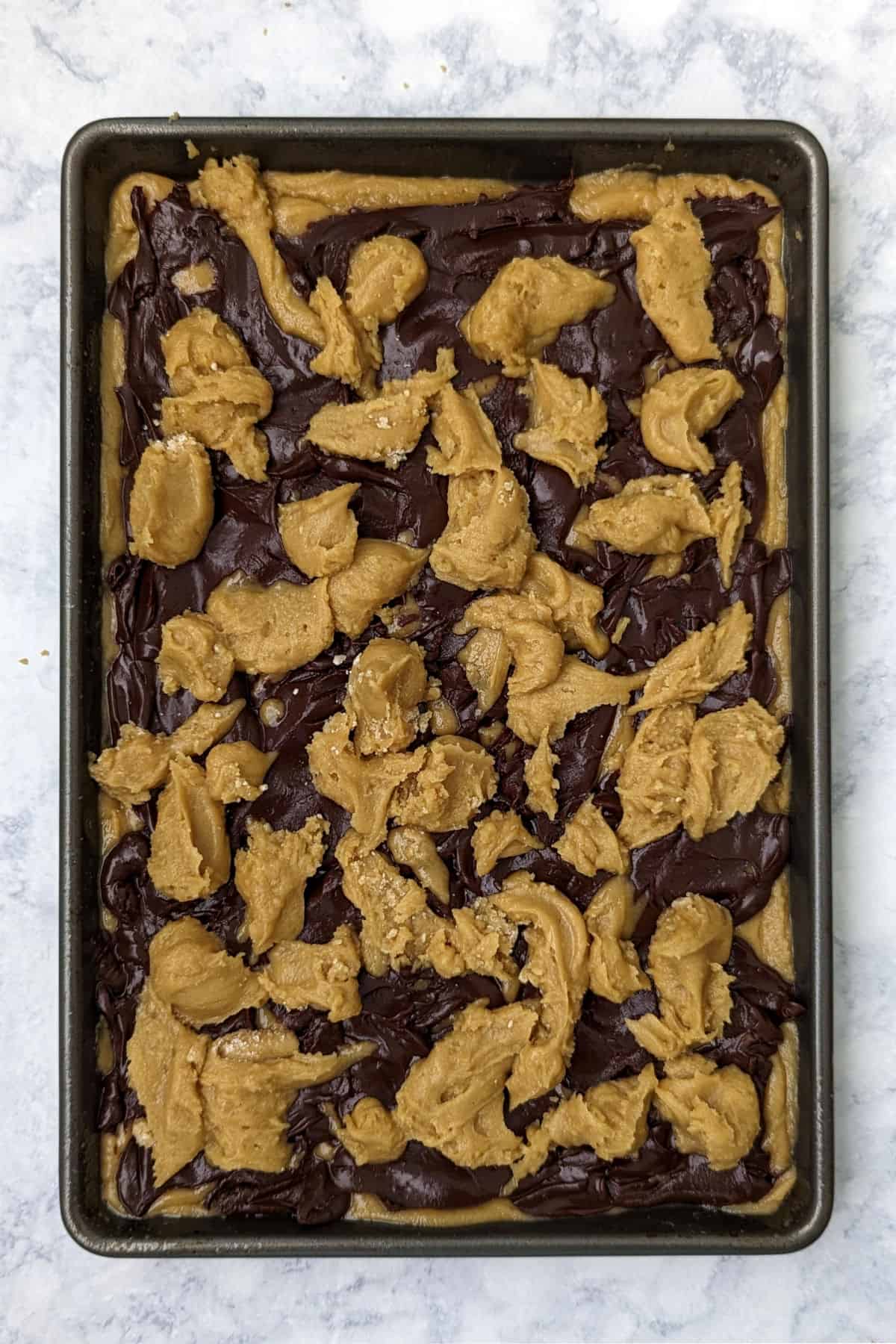 remaining blondie batter dolloped over fudge layer