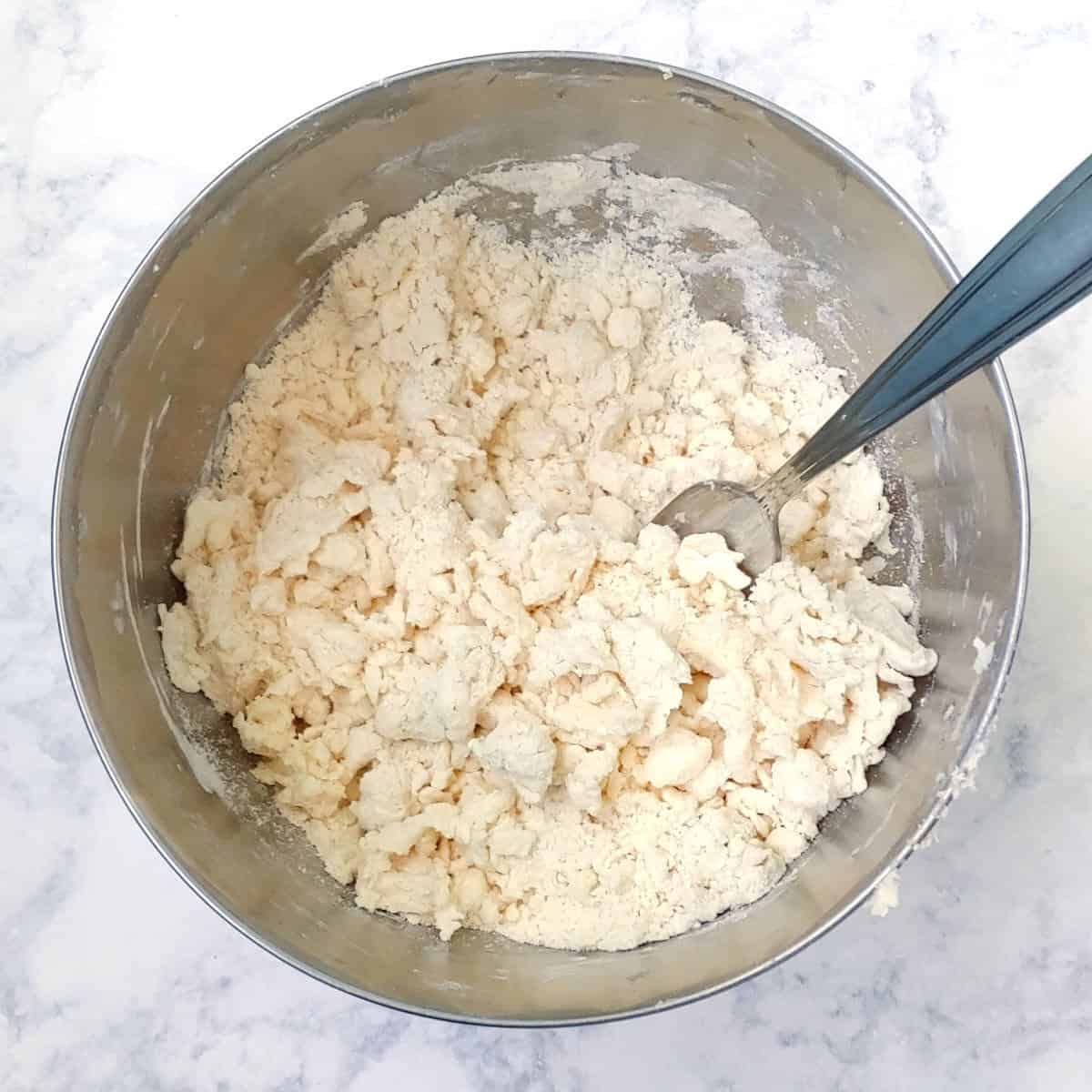 mixing water into flour, butter, and salt, with a fork