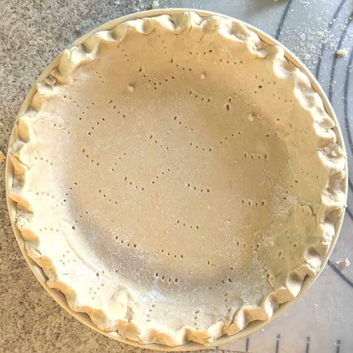 raw pie crust in a pan, before baking, docked