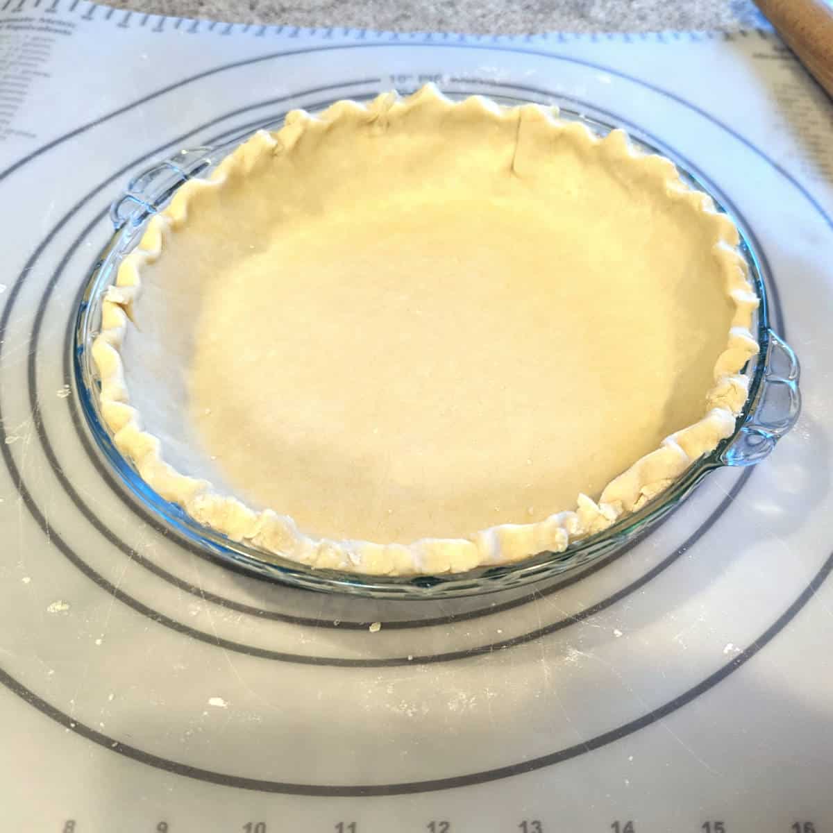 a completed pie crust, raw, before baking, in a pie plate