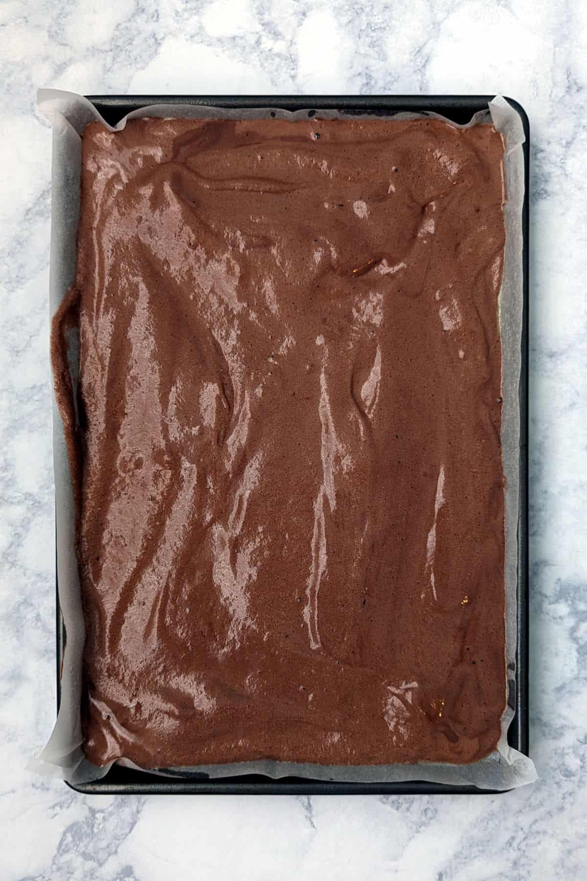 chocolate batter spread to the edges of a jelly roll pan