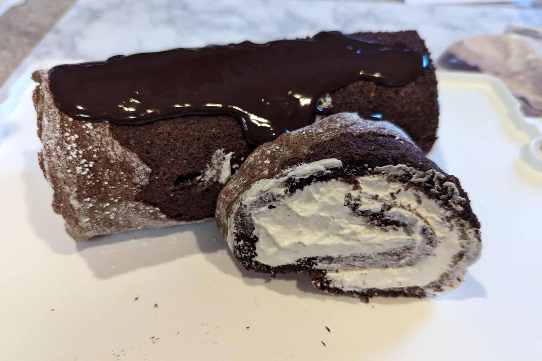 arranged yule log, with chocolate just starting to be drizzled over the top
