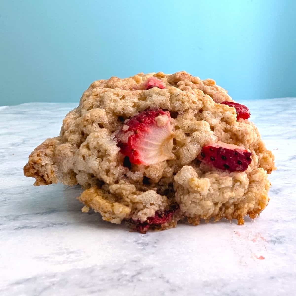 A strawberry and cream scone, propped up to show the top.