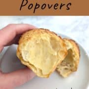 A hand holds a partial popover over a plate to show off its texture. Text overlay for Pinterest reads: Martha Stewart's Popovers. Just 4 ingredients! Made straight from the fridge!