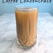 Iced coffee from cold brew coffee concentrate, in a glass with an ice cube. Text overlay for Pinterest reads: Cold Brew Coffee Concentrate. Easy | Homemade. Great for both Iced and Hot Coffee!"