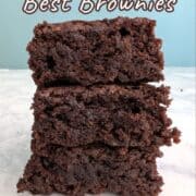 Three brownies stacked on top of each other. Text overlay for Pinterest reads: "Hershey's Best Brownies. Made with Cocoa Powder. A One-Bowl Recipe!"