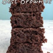 Four brownies stacked on top of each other. Text overlay for Pinterest reads: "Hershey's Best Brownies. Made with Cocoa Powder. A One-Bowl Recipe!"