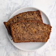Two slices of banana bread, stacked and staggered, on a plate.