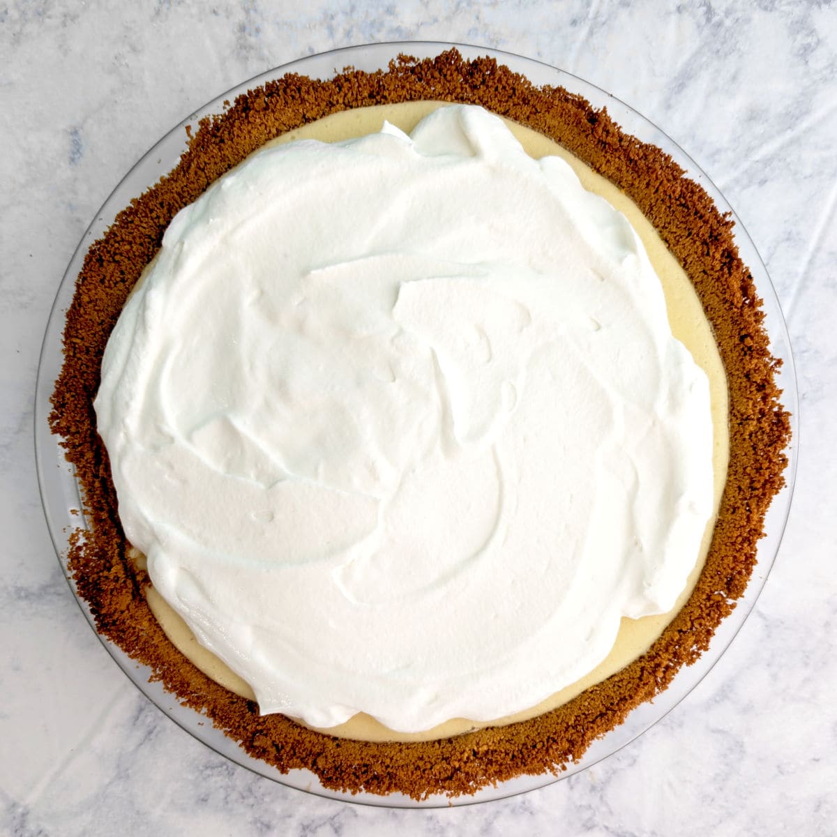 A key lime pie, topped with whipped cream.