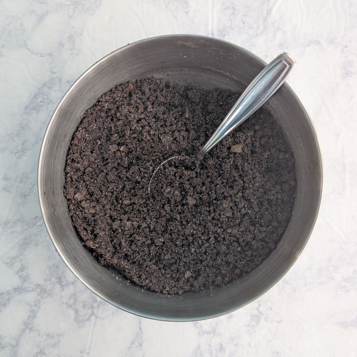 Chocolate graham cracker crust crumbs in a bowl.