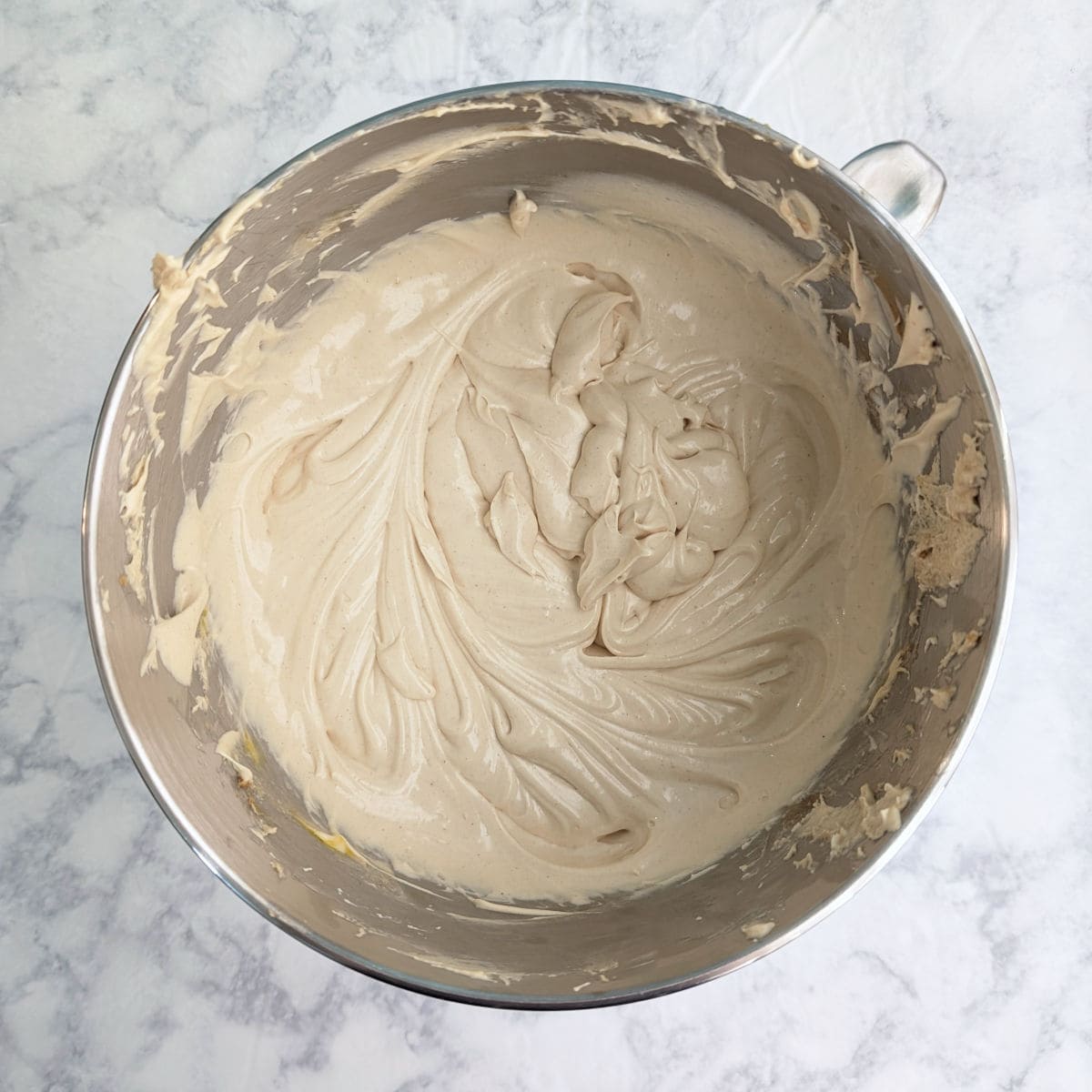 Peanut butter cheesecake batter in a stand mixer bowl.