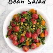 Corn and green bean salad with tomatoes and cilantro on top. Text overlay for Pinterest reads "Corn & Green Bean Salad with Lime."