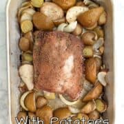 Roasted fennel-coated pork with pears, potatoes, and onions, in a roasting pan. Text overlay for Pinterest reads "Fennel Pork Loin with Potatoes and Pears."