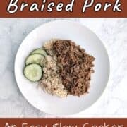 Soy-Cola Braised Pork, plated alongside brown rice and cucumbers. Text overlay for Pinterest reads "An Easy Slow Cooker Recipe!"