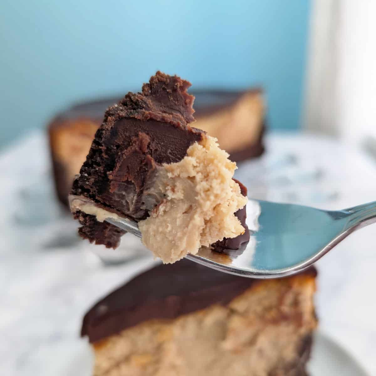 A bite of chocolate peanut butter cheesecake, on a fork.