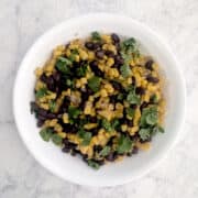 Corn and black beans with mango and cilantro, in a serving bowl.