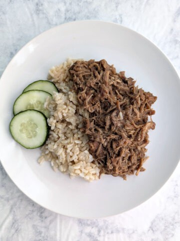 Soy-Cola Braised Pork, plated alongside brown rice and cucumbers.