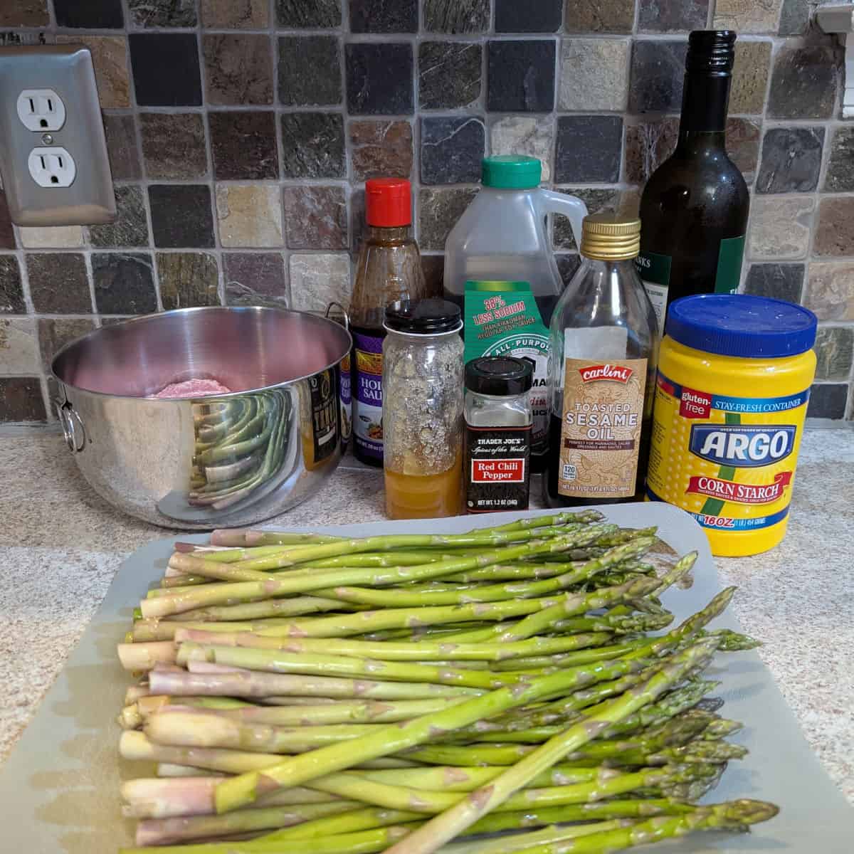 Hoisin sauce, honey, red pepper flakes, lower sodium soy sauce, sesame oil, cornstarch, dry sherry, whole fresh asparagus, and a bowl with ground pork.