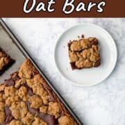 A chocolate oat bar on a plate, next to a pan with the remaining bars. Text overlay for Pinterest reads "Chocolate Oat Bars. Rich and Decadent!"