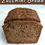 A slice of whole wheat zucchini bread in front of a stack of zucchini bread.
