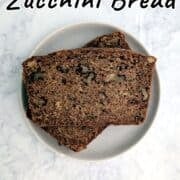 Two slices of Whole Wheat Zucchini Bread, stacked on a plate.