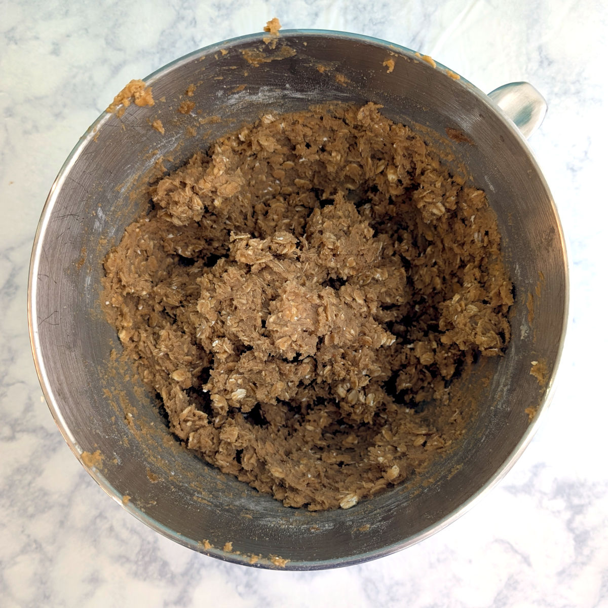 Oatmeal cookie dough in a stand mixer bowl.