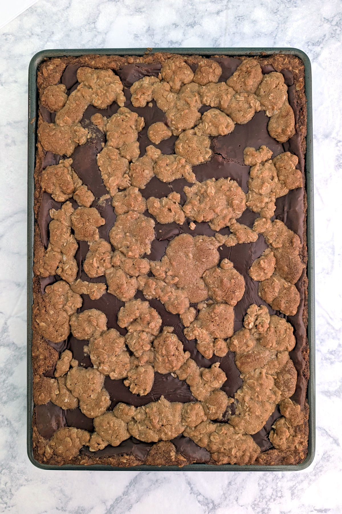 Chocolate oat bars, baked and uncut, in a jelly roll pan.