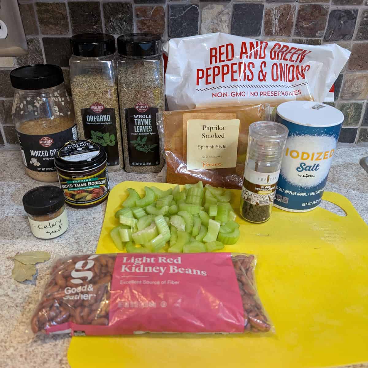 Ingredients for Slow Cooker Red Beans: garlic, oregano, thyme, frozen onions and bell peppers, smoked paprika, salt, black pepper, vegetable bouillon, celery seed, celery, bay leaves, dried red kidney beans.