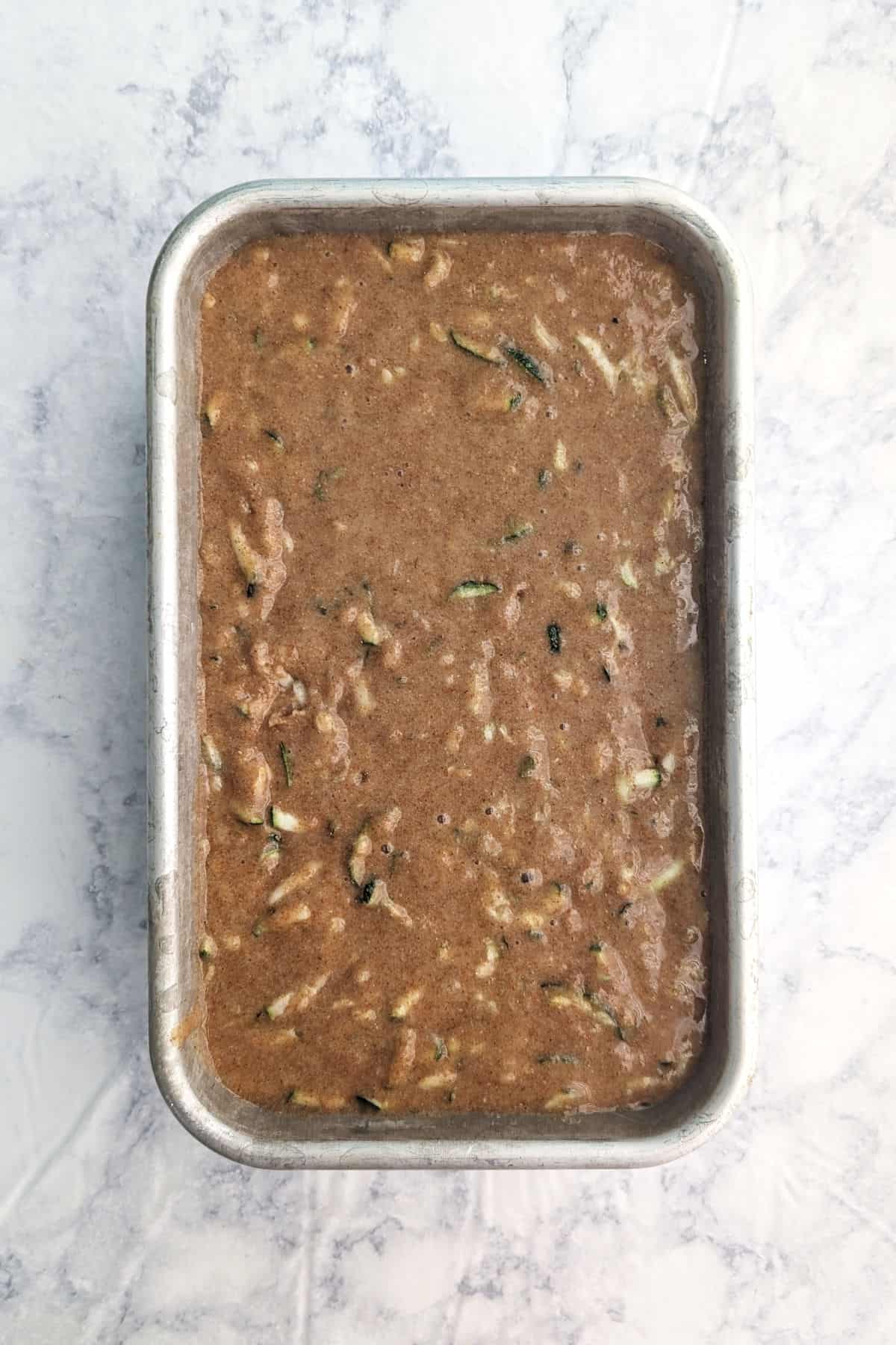 Zucchini bread batter in a loaf pan.