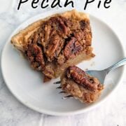 A bite of classic pecan pie on a fork, resting next to the slice of pecan pie on a plate. Text overlay for Pinterest reads "Classic Pecan Pie. Our Family Favorite! Easy As Cookies."