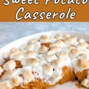 Lightly browned marshmallows on top of soft sweet potatoes in a casserole dish. Half of the sweet potatoes have been served, leaving the other half behind. Text overlay for Pinterest reads "Healthy Sweet Potato Casserole. Easy As Cookies.