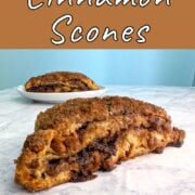 A layered cinnamon scone, seen from the side to see layers. Another scone on a plate is behind it. Text overlay reads "Layered Cinnamon Scones. Easy As Cookies."