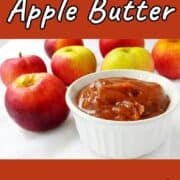 No-sugar-added slow cooker apple butter in a ramekin, in front of apples. Text overlay for Pinterest reads "Slow Cooker Apple Butter. No Sugar Added!"