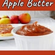 No-sugar-added slow cooker apple butter in a ramekin, in front of apples. Text overlay for Pinterest reads "Slow Cooker Apple Butter. No Sugar Added!"