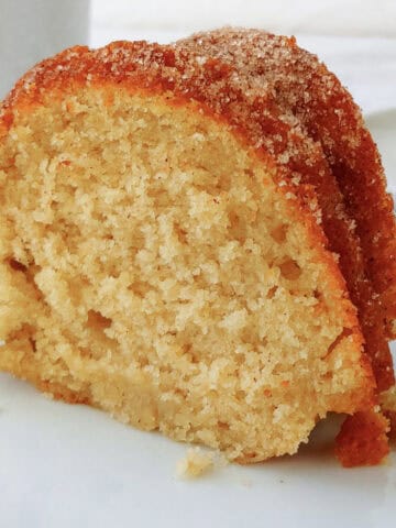 A slice of apple cider donut cake, coated in cinnamon sugar.