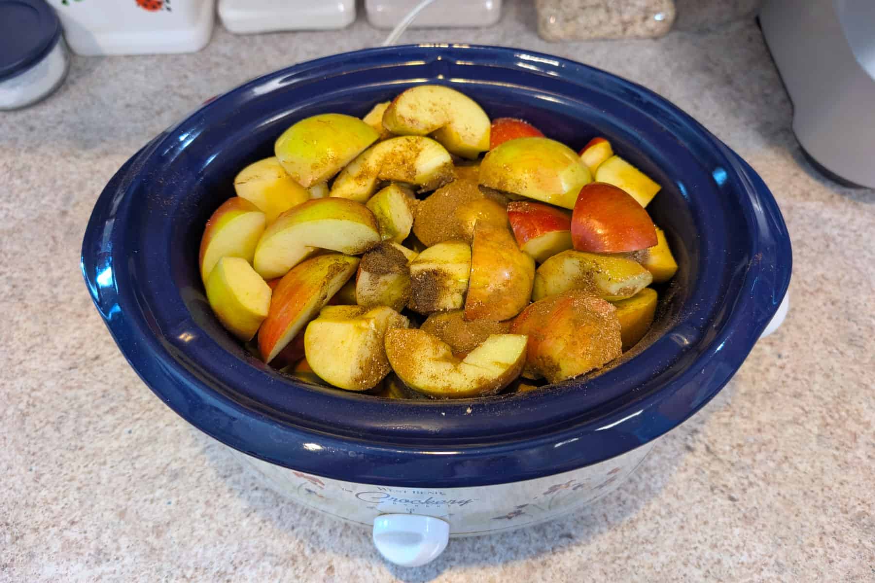 Raw apples with spices in a 3.5 quart slow cooker.