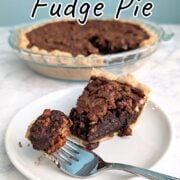 A fork with a bite of Pecan Fudge Pie rests on a plate with the slice. The remaining pie is in the background. Text overlay reads "Pecan Fudge Pie. Rich & Chocolatey. Easy As Cookies."