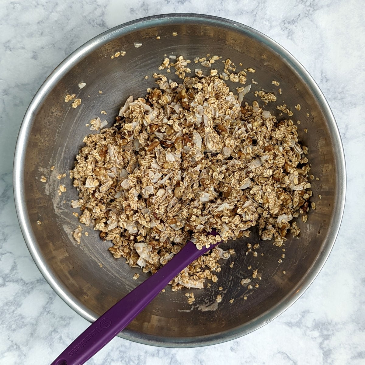 Aquafaba granola mixture in a large mixing bowl, before being baked.