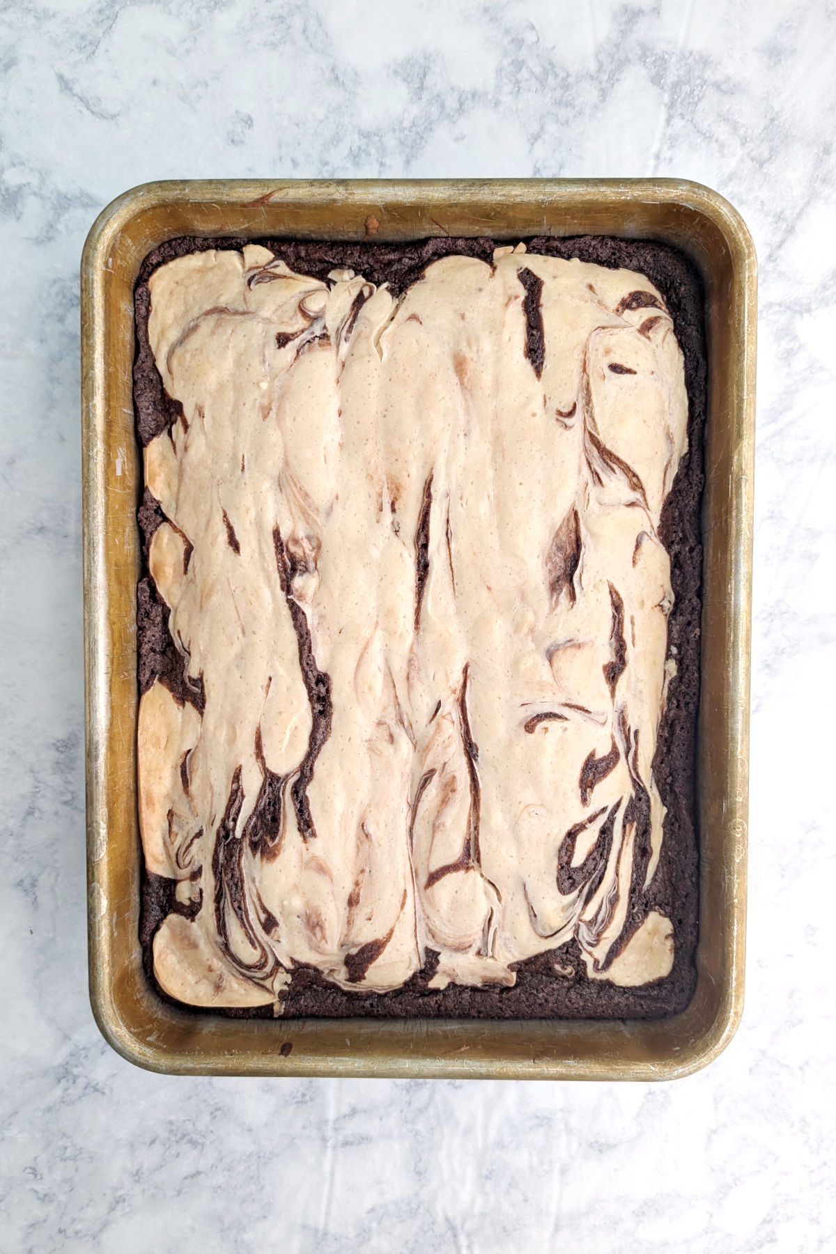 Baked cheesecake brownies in a metal 9x13 inch pan.