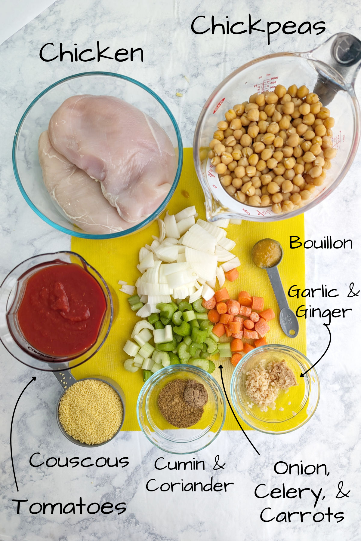 A picture with ingredients labeled for Stewed Chicken and Chickpeas, including: chicken breasts, chickpeas, crushed tomatoes, dry couscous, onion, celery, carrot, cumin, coriander, garlic, ginger, and chicken bouillon.