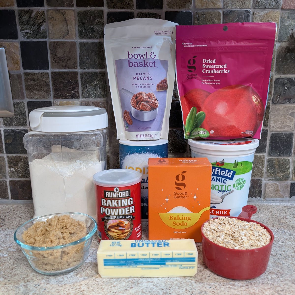 Ingredients for Cranberry Oat Pecan Scones: flour, salt, pecans, dried cranberries, yogurt, brown sugar, baking powder, baking soda, rolled oats, and butter.