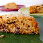 A Cranberry Oat Pecan Scone on a green plate. Other scones are on red and green plates in the background.
