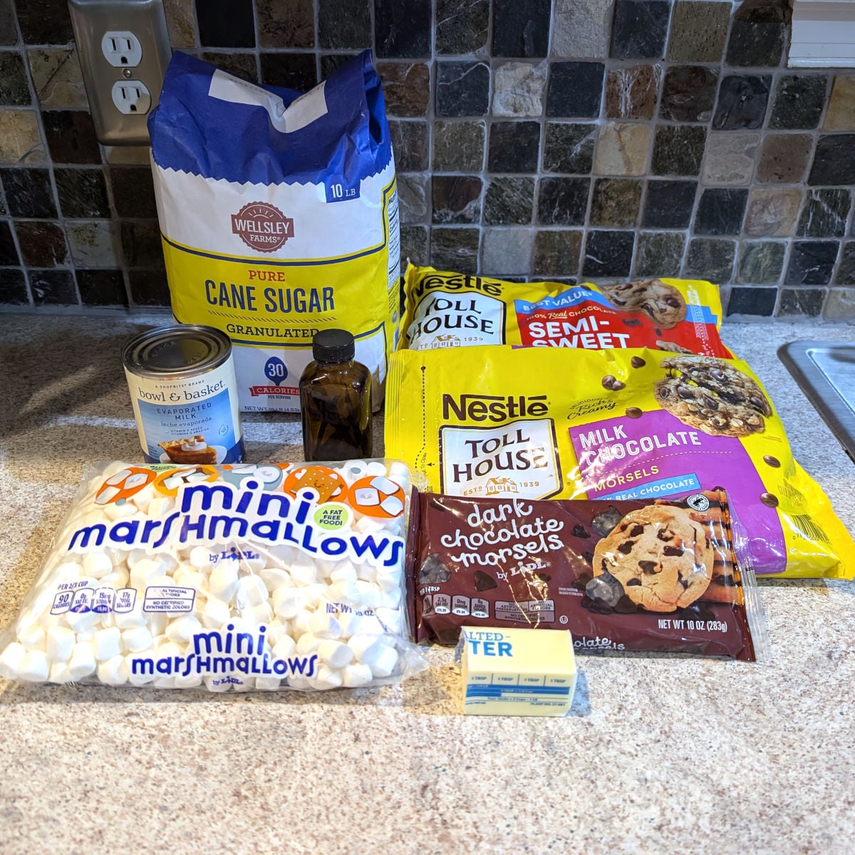 Ingredients for easy chocolate fudge: sugar, semisweet chocolate, evaporated milk, vanilla, milk chocolate, dark chocolate, miniature marshmallows, butter.