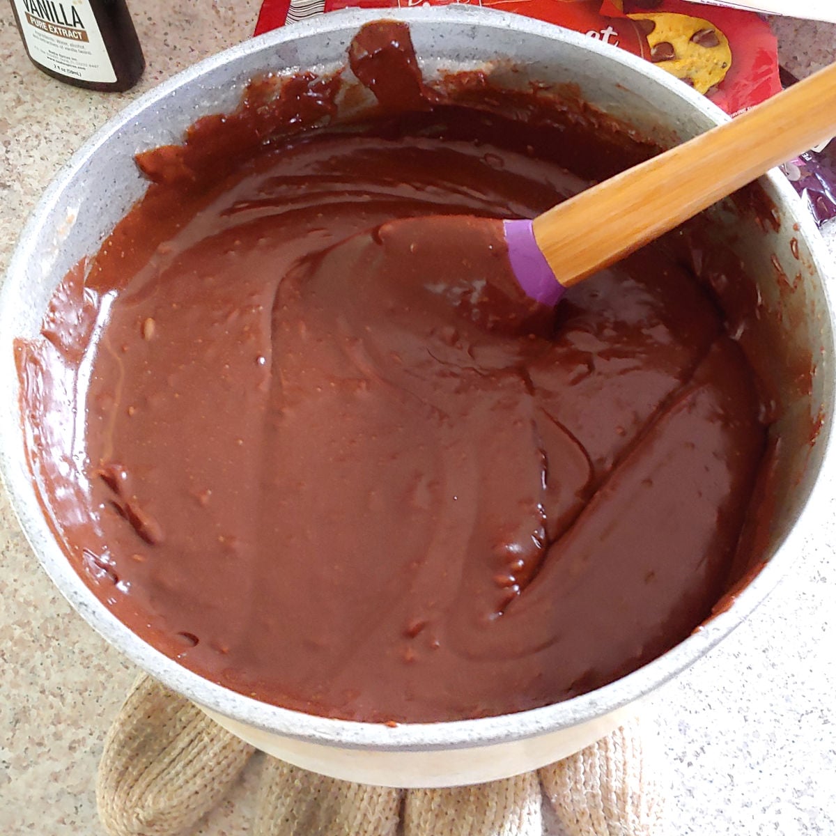 Chocolate fudge mixture in a pot while it's being mixed.