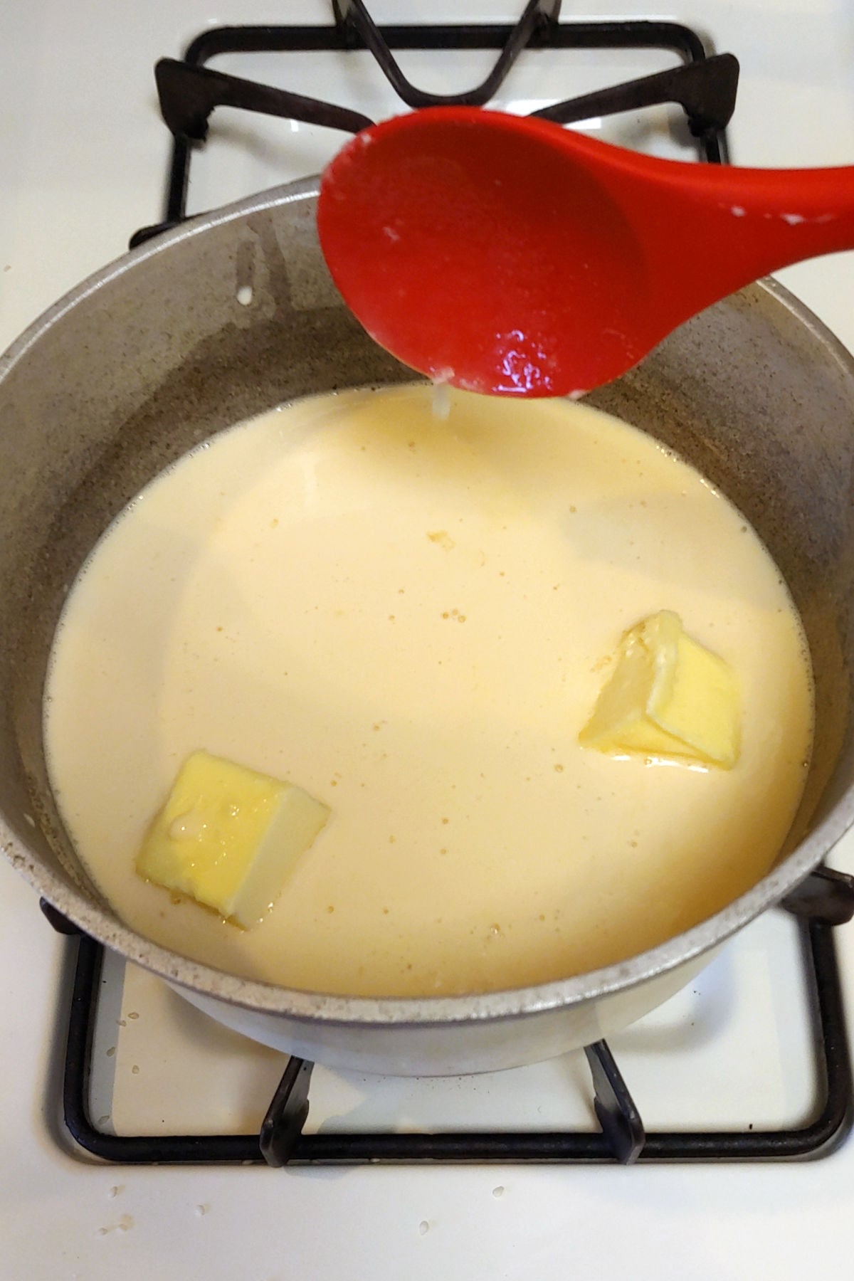 Butter, sugar, and evaporated milk, in a pot on the stove.