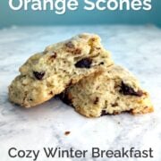 Chocolate orange scones torn open to show texture and stacked at an angle. Text overlay reads "Chocolate Orange Scones. Cozy Winter Breakfast. Make-Ahead Friendly. Easy As Cookies."