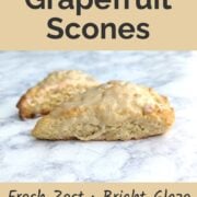 Two grapefruit scones, on a counter, shown from the side to see the texture. Text overlay reads "Fresh Grapefruit Scones. Fresh Zest, Bright Glaze, Egg-Free. Easy As Cookies."