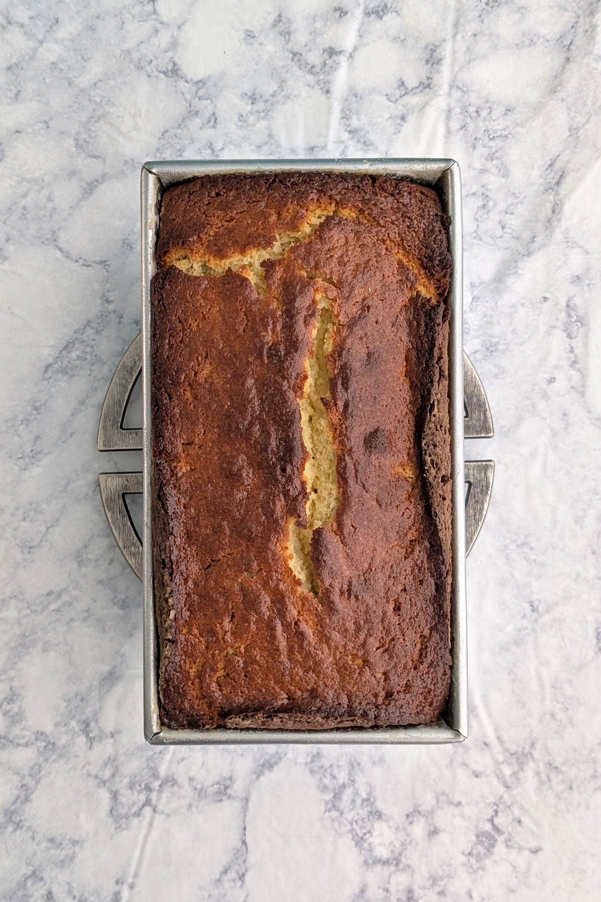 Ricotta pound cake, baked, seen from overhead in a loaf pan.